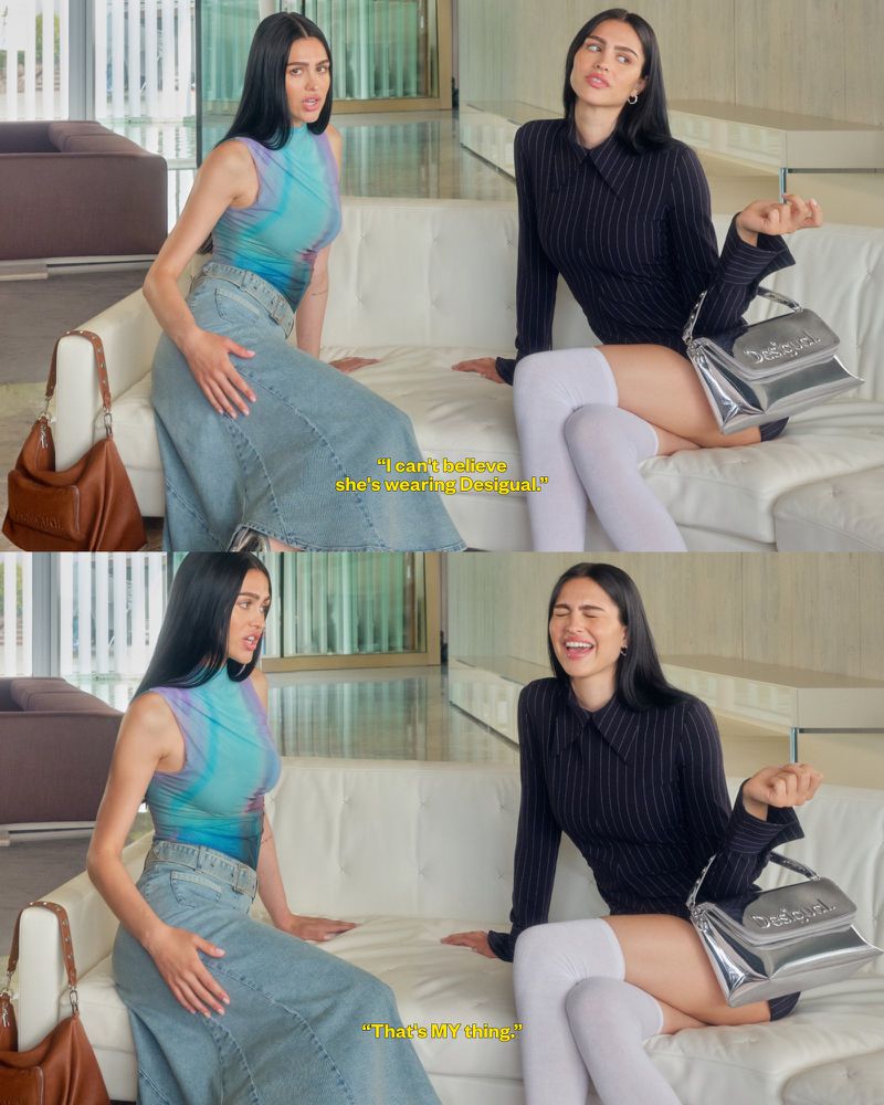 Two women are sitting on a white couch in a modern interior; one wearing a blue top and long denim skirt, the other in a black mini-dress.
