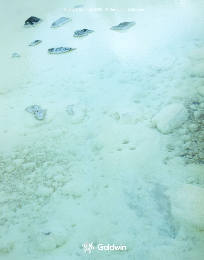 Abstract aerial view of a blue-green hot spring with white mineral deposits and scattered rocks, evoking a sense of calm and wonder.