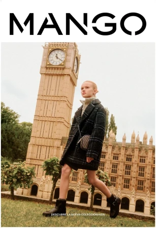 A young girl in a plaid coat and black boots poses in front of a building with a clocktower for a Mango Kids ad campaign.
