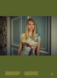 Model Annie Arnander wearing a patterned dress against blue paneled doors for Harper's Bazaar Germany