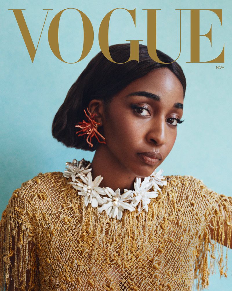 Vogue cover featuring a black woman with dark hair and wearing a white and tan crocheted top, coral earrings, and a beaded necklace.