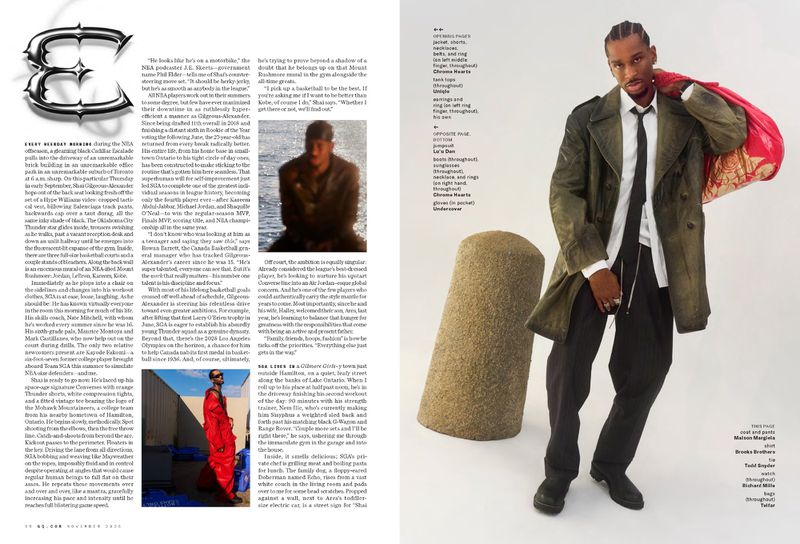 A man in an olive green trench coat and black tie stands against a white background with geometric objects and a red bag.