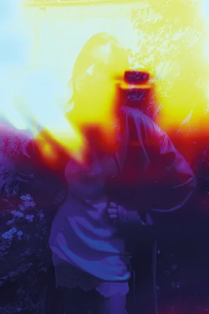 Model Irina Shayk standing with hands on hips enveloped in heavy yellow and red film light leaks for Self Service.