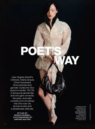 Editorial fashion shot: Young Asian woman poses in a lace-trimmed dress, holding a black purse against a dark backdrop. Fashion magazine.