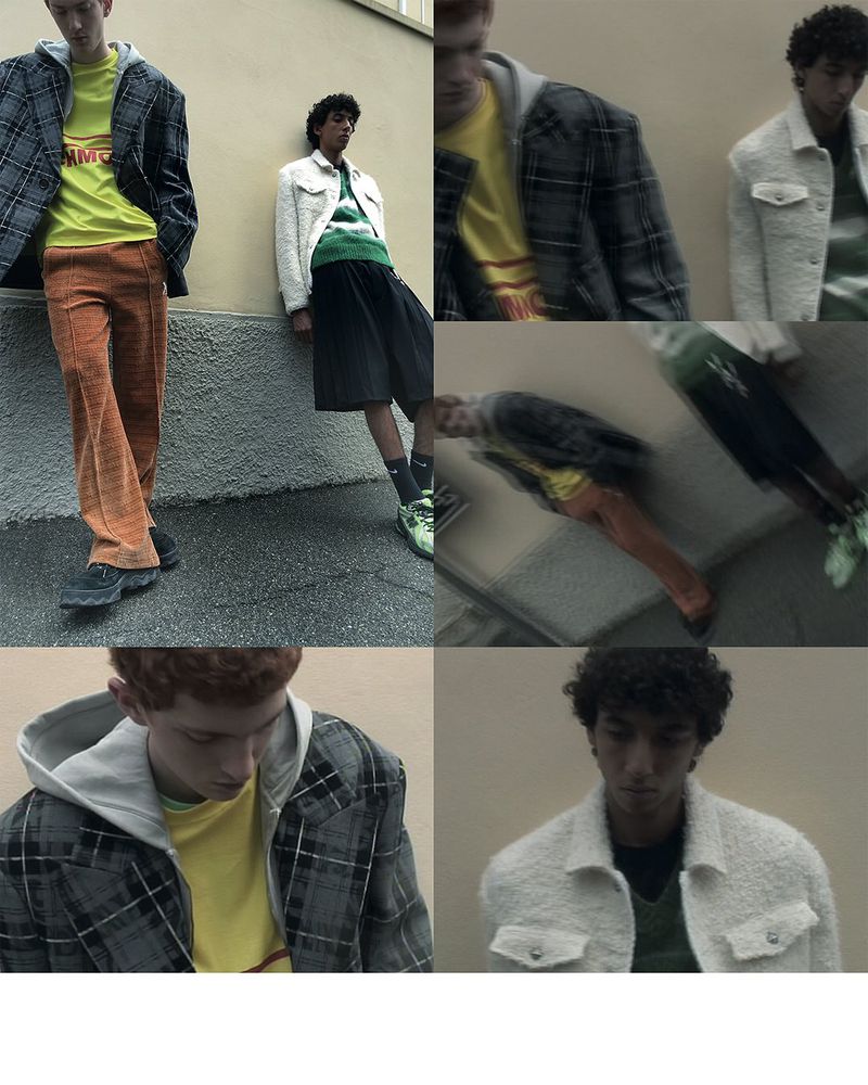 Two young men in outdoor fashion editorial: one in a gray plaid jacket and orange pants, the other in a white jacket and black shorts.