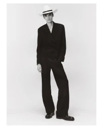 Model in a black suit and white hat against a light background for Downton Chapter 1 by U Repubblica
