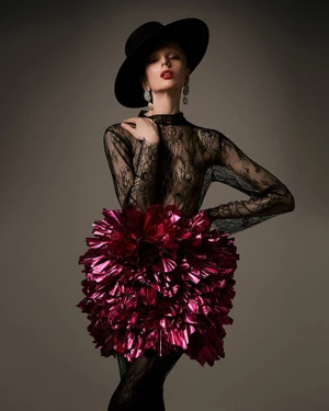 Model Chrystal Copland wearing a sheer black lace top, metallic magenta ruffled skirt, and wide-brim hat by photographer Jesús Villanueva Varela.