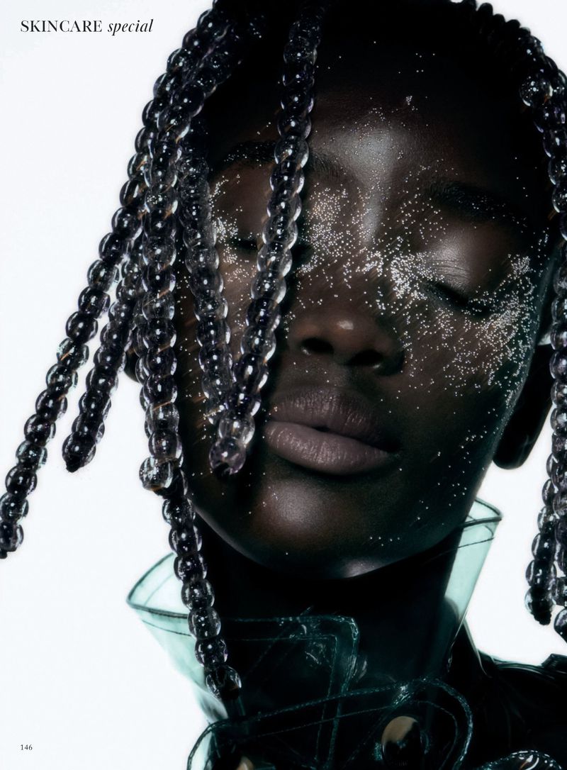 Close-up beauty shot of a woman with braided hair and glittering makeup. The image highlights skincare and beauty aesthetics.