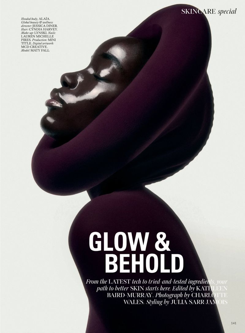 Profile of an African American woman with high-gloss skin wearing a plum-colored knit hood and top against a clean, light background.