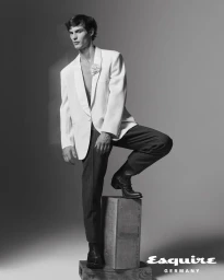 Kit Butler posing in a white tuxedo jacket and dark trousers for Esquire Germany editorial