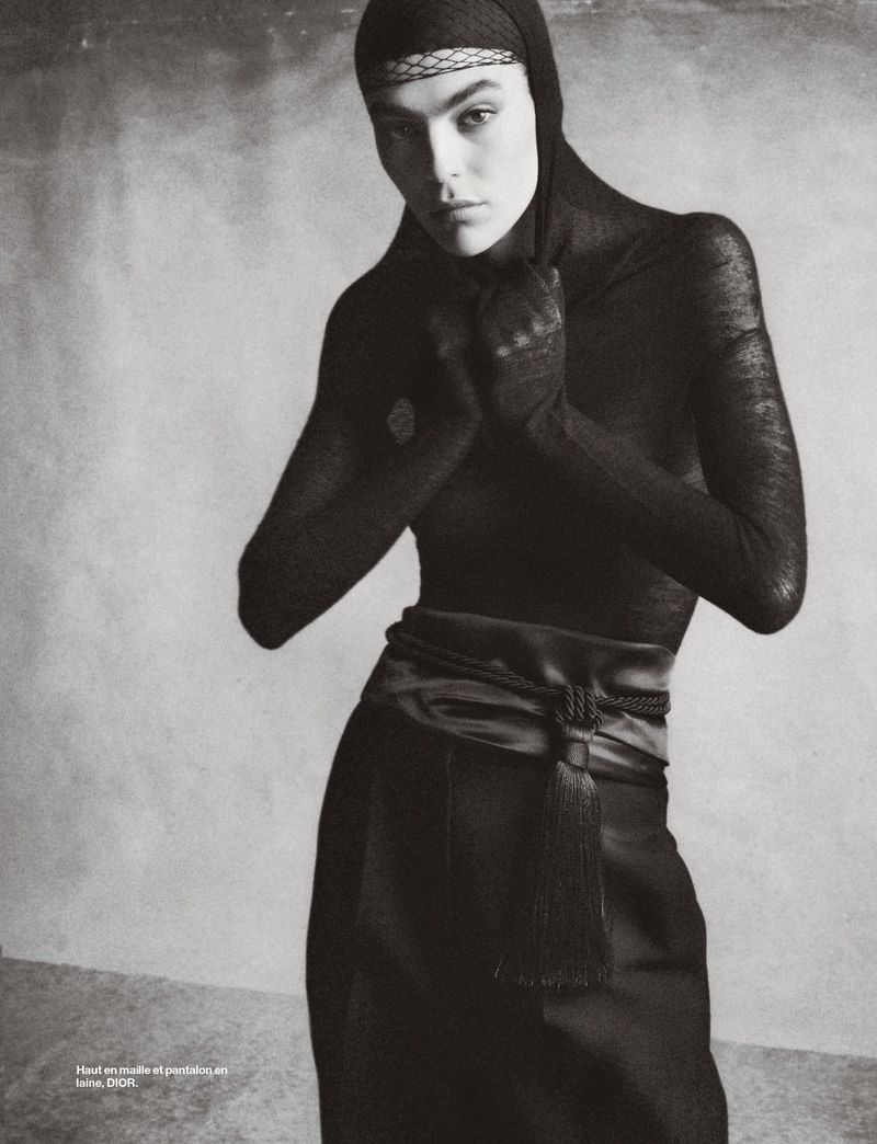 Julia Pacha poses in a black hooded top and tassel belt in a black and white fashion editorial for Numéro France.