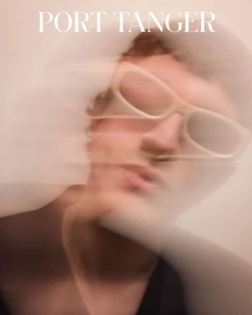 Abstract portrait of a fair-skinned person wearing sunglasses, captured in a soft, blurred motion against a neutral background with text.