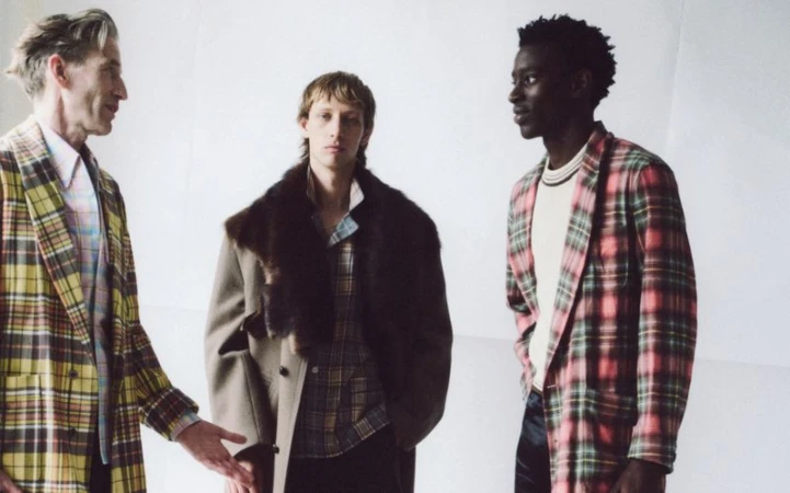 Three adult male fashion models pose in a photo studio wearing vintage-inspired plaid blazers, creating a classic retro vibe.