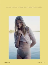 Model standing outdoors near water wearing light pink top and matching underwear for Vanity Fair Italia editorial