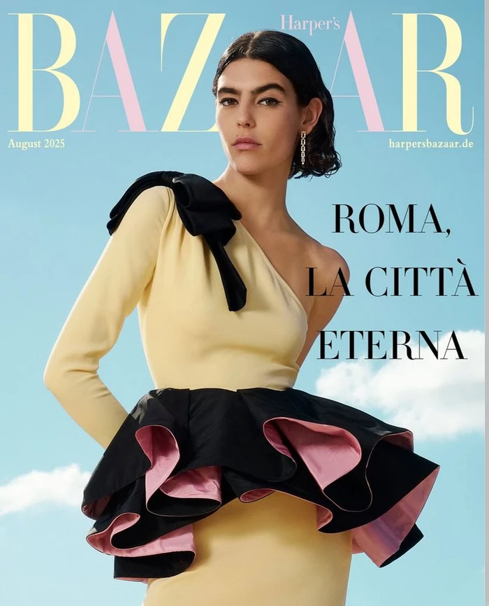 Model Julia Pacha wearing a yellow dress with black ruffles against a bright sky background for Harper's Bazaar Germany.