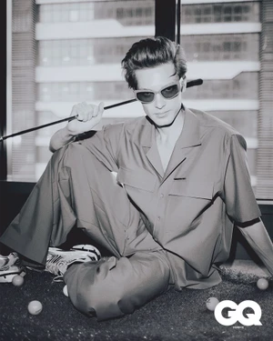 Monochrome fashion editorial portrait of male model Roman Muravev holding a golf club for GQ Turkey