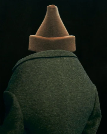 Back view of a person wearing a grey coat and a brown dunce cap against a dark background. The hat is cone-shaped and sits squarely.
