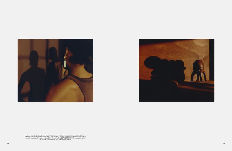 Indoor lifestyle shot featuring three adult women in activewear, one with earrings, in a fitness or yoga studio setting with wood sculpture art.