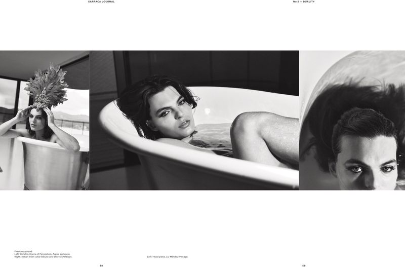 Black-and-white fashion editorial featuring a young adult in a bathtub wearing a feather headdress, conveying a vintage aesthetic.