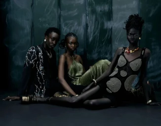 Three Black models in designer eveningwear posed against a dark textured backdrop for Tidal Magazine.