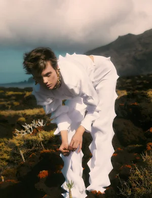 Model Maaike Klaasen in white textured clothing outdoors in a volcanic landscape for Numéro Switzerland editorial