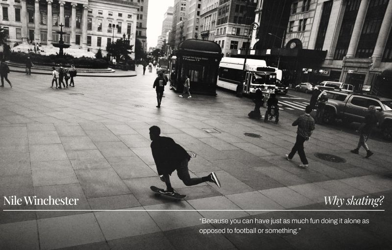 Monochrome shot of a male skateboarder riding on a city plaza with pedestrians and urban elements in the background. Editorial style.