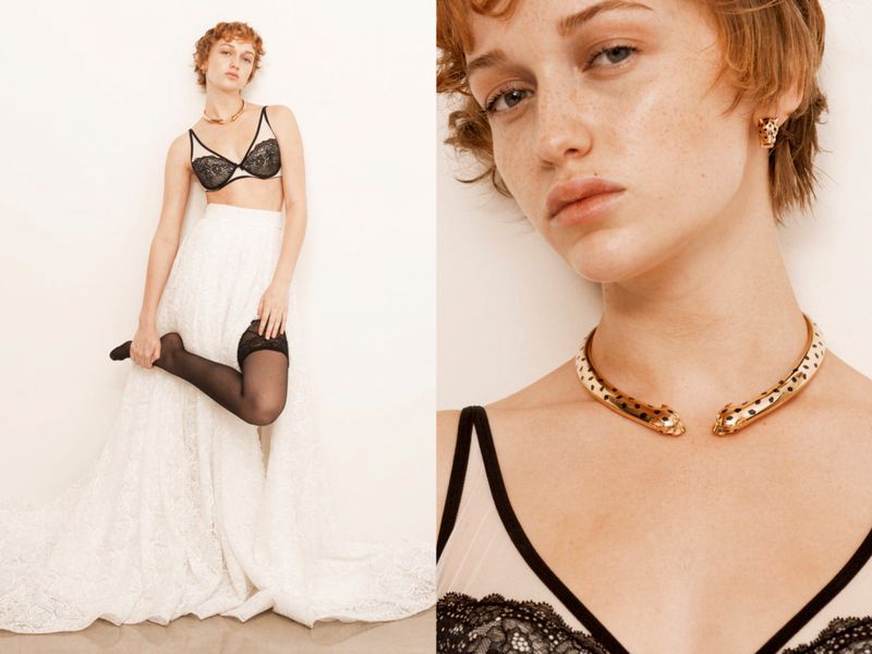 A redhead fashion model poses in a bra top, lace skirt, and thigh-highs against a white wall, showcasing a gold leopard necklace and earring set.