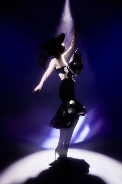 A woman in a black and white polka dot dress poses dramatically in a spotlight, showcasing fashion and avant-garde style in a dark studio.