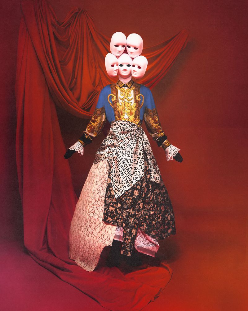 Fashion editorial featuring a mannequin wearing a blue and gold jacket, skirt of mixed fabrics, and cluster of masks for a headpiece.