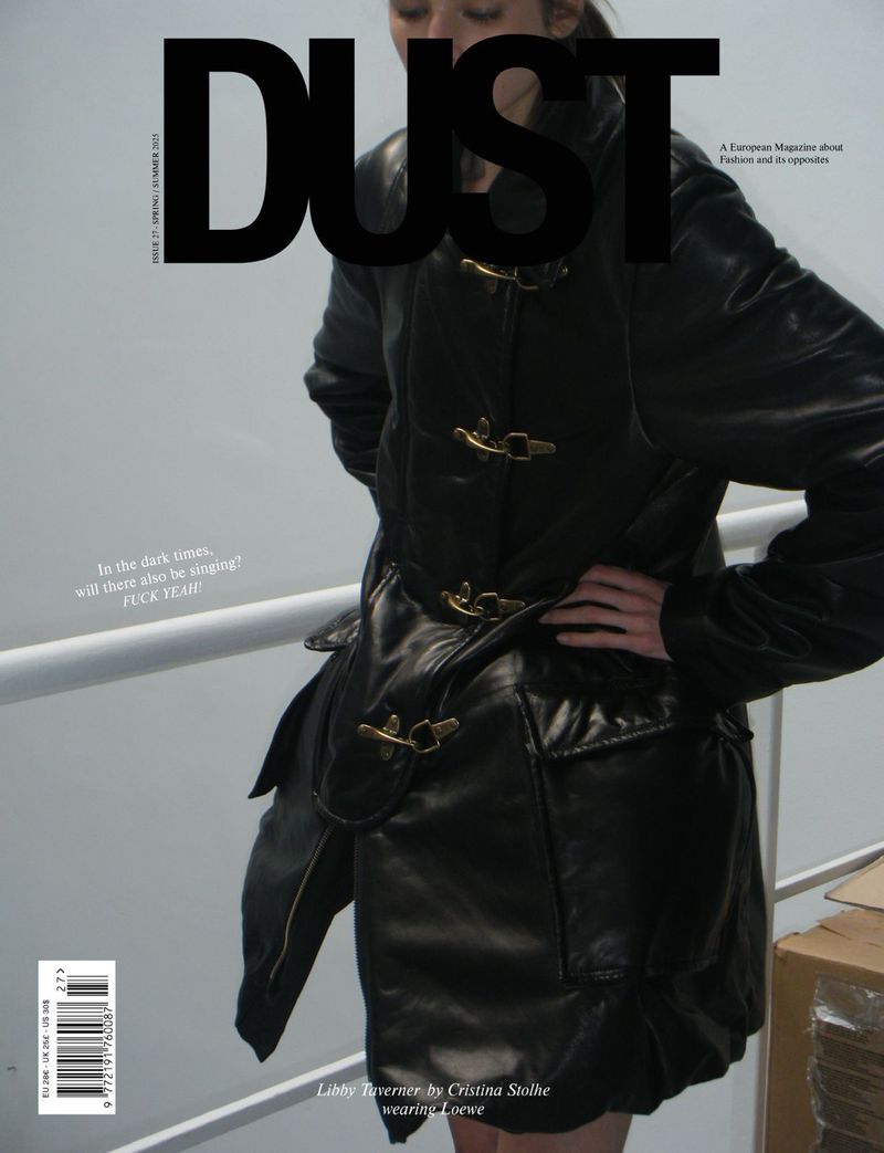 Dust magazine cover featuring an adult female model in a dark leather coat, posing indoors in front of a staircase and white railing.