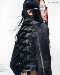 Model wearing dark wrap-around sunglasses and a laced-up denim jacket against a bright white background for D Repubblica