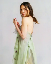 Olivia Munn wearing a pale green sleeveless dress against a light neutral grey background for a Self Magazine portrait.