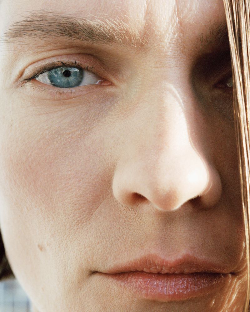 Extreme close-up portrait of model Karolin Wolter highlighting skin texture, a bright blue eye, and natural lighting.