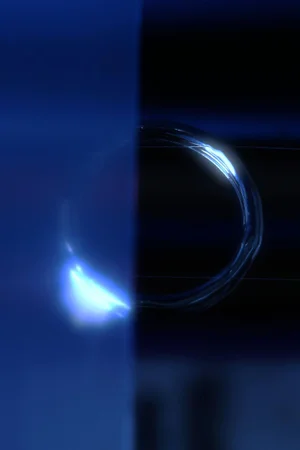 Close-up abstract shot of a translucent circular Lucite ring reflecting blue light against a deep navy and black split backdrop.
