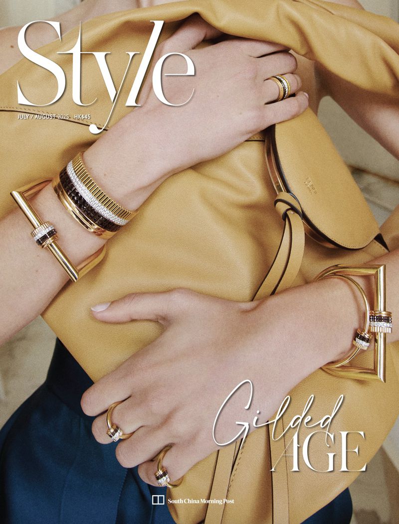 Close-up fashion shot of a woman's hands adorned with gold jewelry, holding a tan leather purse. Magazine cover reads 'Style'.