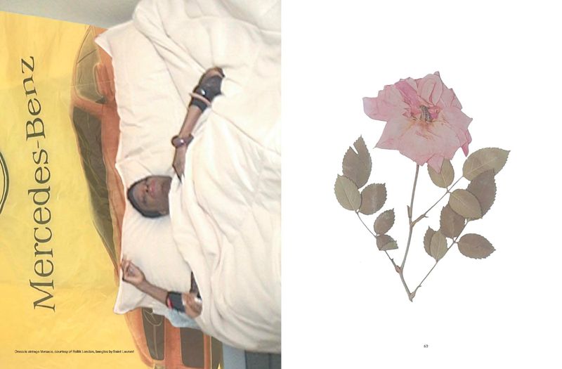 Adult lying in a bed with a white blanket, posed in front of a Mercedes-Benz sign and a pink rose on a white backdrop.