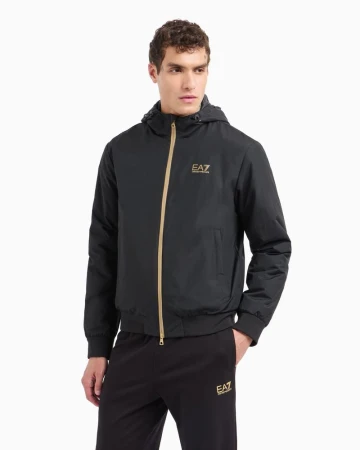 Male model in a black hooded zip-up jacket and matching trousers against a plain white studio background.