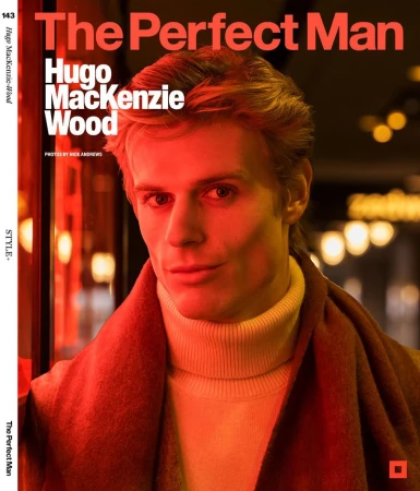 Magazine cover featuring a close-up of a fair-skinned adult man with blonde hair wearing a turtleneck and scarf, set against a blurred background.