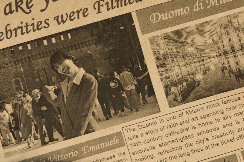 Monochrome photo of a woman laughing and a cityscape on a newspaper, focusing on people and architecture captured in print.
