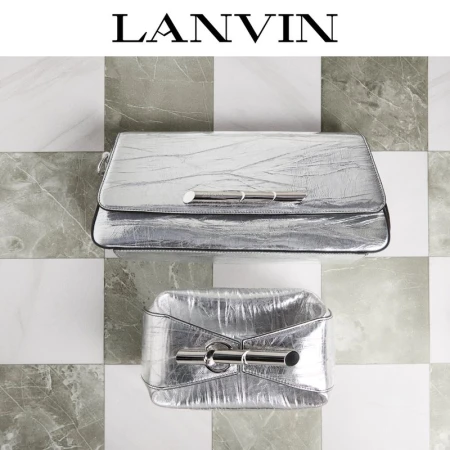 Two metallic silver Lanvin handbags with a metal bar detail are set against a checkered grey and white tile background, product shot.