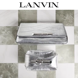 Two metallic silver leather handbags displayed on a green and white checkered tiled surface for Lanvin accessories Fall 2024.