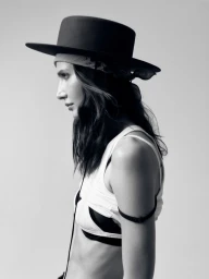 Monochrome portrait of a female model wearing a wide-brimmed flat hat and white tank top against a plain light background