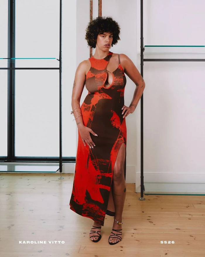 Model Luna Freddie in a red and brown graphic cutout maxi dress and black strappy heels for Karoline Vitto.