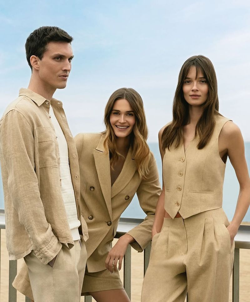 Three fashion models in tan linen clothing pose against a bright sky in a sunny outdoor setting, showcasing modern style.