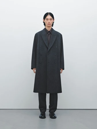 Model Taemin Park wearing an oversized dark charcoal overcoat and trousers against a clean white studio backdrop.
