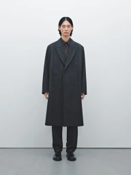Model Taemin Park wearing an oversized dark charcoal overcoat and trousers against a clean white studio backdrop.