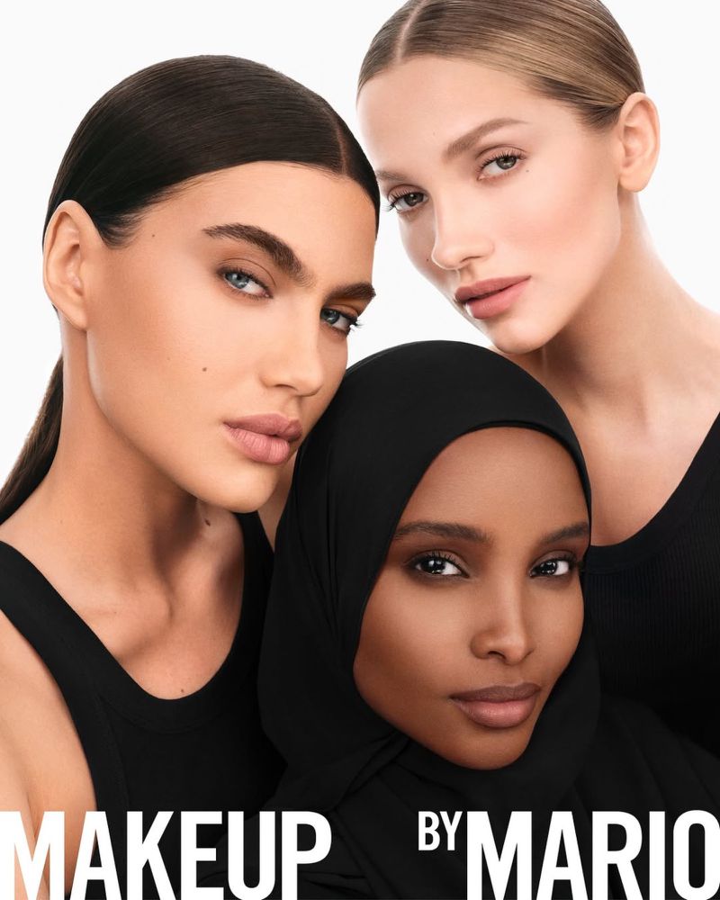 Close-up beauty shot of three diverse women with makeup, wearing black tops against a white backdrop, highlighting makeup artistry.