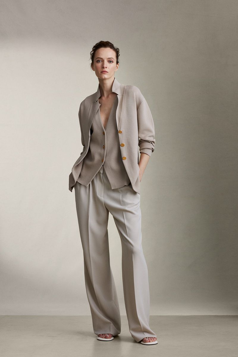 Model wearing a beige button-down cardigan and matching wide-leg trousers against a neutral studio background.