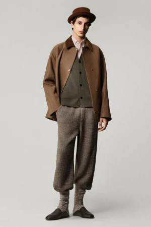 Full-length studio shot of a man wearing a brown bowler hat, coat, vest, shirt, trousers, socks, and shoes, standing against a neutral background.