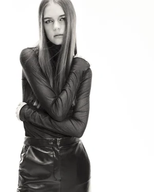 Model Tilda Jonsson in a long-sleeved black turtleneck and tailored leather pants posing against a seamless white background.